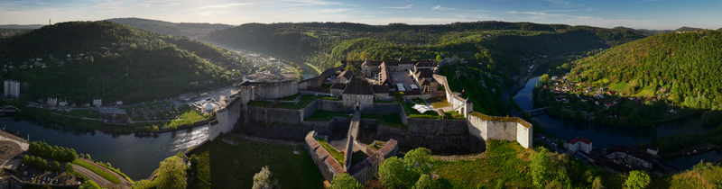 Aerial view of the historic Besancon Citadel perched on a hilltop overlooking the Doubs river and lush green valleys in Besancon Bourgogne Franche Com France. Aerial view of the historic Besancon Citadel perched on a hilltop overlooking the Doubs river and lush green valleys in Besancon Bourgogne Franche Com France.