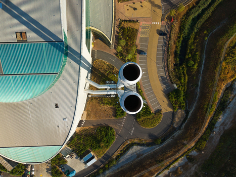 Aerial view of the Energy Recovery Facility featuring large industrial chimneys a curved roof and adjacent parking areas in Bicester England United Kingdom.