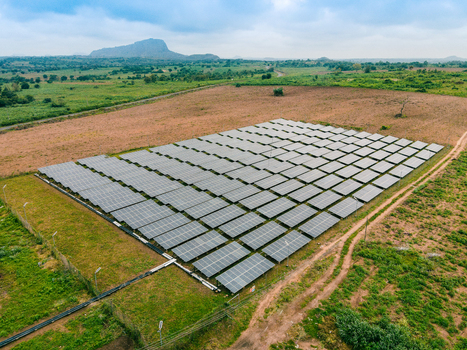 Aerial view of a large solar farm with rows of photovoltaic panels installed in a rural landscape in Ogun State Nigeria.