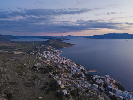 Aerial view of Saranda coastal town with buildings along the shoreline hills and the Ionian Sea at sunset in Saranda Vlore County Albania. Aerial view of Saranda coastal town with buildings along the shoreline hills and the Ionian Sea at sunset in Saranda Vlore County Albania.