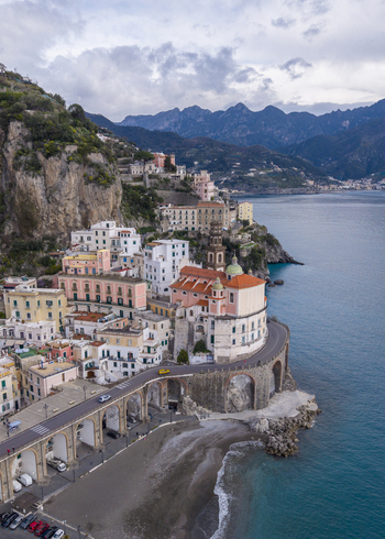 Aerial view of Atrani town and buildings perched along the Amalfi Coast where the rugged cliffs meet the turquoise sea Atrani Italy. Aerial view of Atrani town and buildings perched along the Amalfi Coast where the rugged cliffs meet the turquoise sea Atrani Italy.