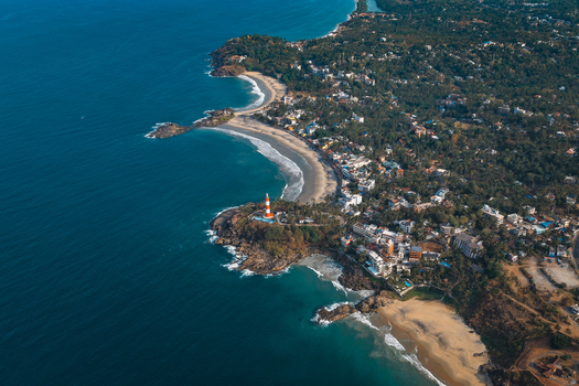 Aerial view of Vizhinjam Lighthouse on a rocky headland overlooking sandy beaches and the Arabian Sea in Kovalam Kerala India. Aerial view of Vizhinjam Lighthouse on a rocky headland overlooking sandy beaches and the Arabian Sea in Kovalam Kerala India.