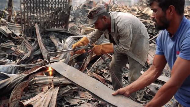 View of workers cutting metal with a blowtorch in a scrapyard Bangladesh. View of workers cutting metal with a blowtorch in a scrapyard Bangladesh.