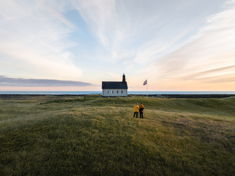 Aerial view of a quaint church standing proudly against the horizon bathed in the serene glow of the Icelandic sky Sveitarf&eacute;lagi&eth; &Ouml;lfus Iceland.