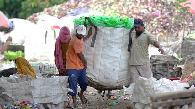 View of workers carrying a large bag of plastic bottles Bangladesh. View of workers carrying a large bag of plastic bottles Bangladesh.