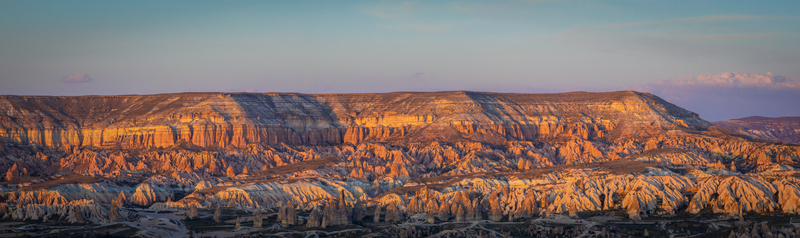 Aerial view of Rose Valley featuring unique fairy chimneys and rugged rock formations illuminated by golden hour light in Goreme Nevsehir Turkiye. Aerial view of Rose Valley featuring unique fairy chimneys and rugged rock formations illuminated by golden hour light in Goreme Nevsehir Turkiye.