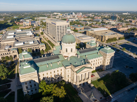 Aerial view of the Indiana Statehouse with its iconic green copper dome and neoclassical architecture surrounded by the urban landscape of downtown Indianapolis Indiana United States. Aerial view of the Indiana Statehouse with its iconic green copper dome and neoclassical architecture surrounded by the urban landscape of downtown Indianapolis Indiana United States.