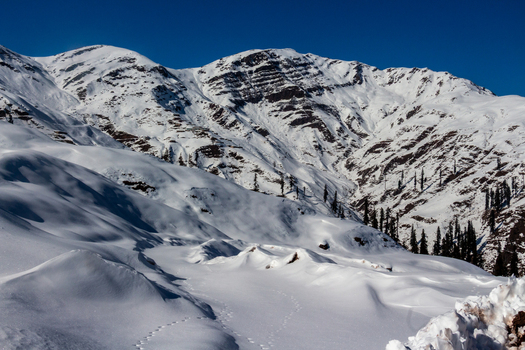View of snow covered mountains under a crisp blue sky creating a serene winter landscape a snowy wonderland Haveli Azad Kashmir Azad Kashmir Pakistan.