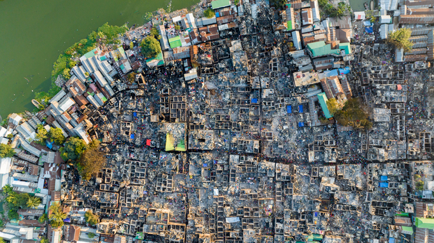 Aerial view of devastation after a fire with scattered debris and remnants of homes a stark contrast to the adjacent unaffected buildings Dhaka Dhaka Division Bangladesh. Aerial view of devastation after a fire with scattered debris and remnants of homes a stark contrast to the adjacent unaffected buildings Dhaka Dhaka Division Bangladesh.