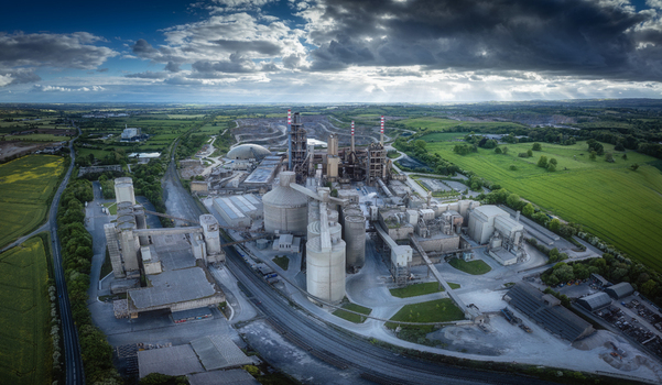 Aerial view of Irish Cement Ltd factory with industrial silos and chimneys under a dramatic cloudy sky in Drogheda County Louth Ireland. Aerial view of Irish Cement Ltd factory with industrial silos and chimneys under a dramatic cloudy sky in Drogheda County Louth Ireland.