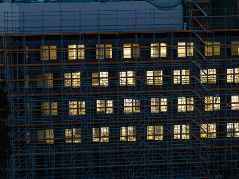 Aerial view of the Adlershof building illuminated at night covered in extensive metal scaffolding during construction work in Berlin Berlin Germany. Aerial view of the Adlershof building illuminated at night covered in extensive metal scaffolding during construction work in Berlin Berlin Germany.