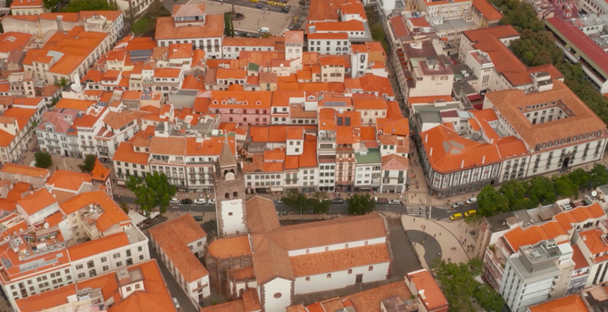 Aerial view of Funchal Cathedral surrounded by historic buildings with orange tiled roofs and narrow streets in the city center of Funchal Madeira Portugal. Aerial view of Funchal Cathedral surrounded by historic buildings with orange tiled roofs and narrow streets in the city center of Funchal Madeira Portugal.