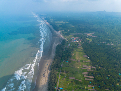 Aerial view of the long sandy coastline with turquoise waves crashing on the shore and lush green forest along the beach in Cox s Bazar Chittagong Division Bangladesh. Aerial view of the long sandy coastline with turquoise waves crashing on the shore and lush green forest along the beach in Cox s Bazar Chittagong Division Bangladesh.