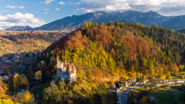 Aerial view of Bran Castle surrounded by vibrant autumn foliage and forested hills in the Carpathian Mountains near Bran Brasov Romania. Aerial view of Bran Castle surrounded by vibrant autumn foliage and forested hills in the Carpathian Mountains near Bran Brasov Romania.