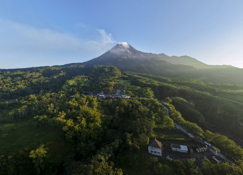Aerial view of Bunker Kaliadem Merapi at the foot of Mount Merapi volcano surrounded by lush green forests and roads Kecamatan Pakem Daerah Istimewa Yogyakarta Indonesia. Aerial view of Bunker Kaliadem Merapi at the foot of Mount Merapi volcano surrounded by lush green forests and roads Kecamatan Pakem Daerah Istimewa Yogyakarta Indonesia.
