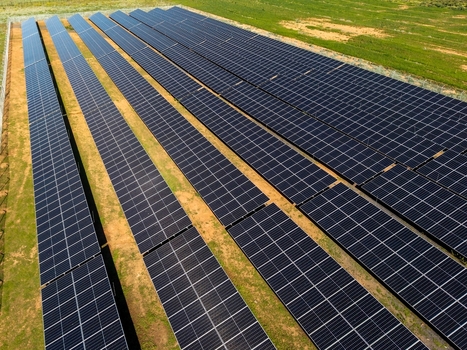 Aerial view of a large solar farm with rows of photovoltaic panels installed on open land in Ladismith Western Cape South Africa. Aerial view of a large solar farm with rows of photovoltaic panels installed on open land in Ladismith Western Cape South Africa.