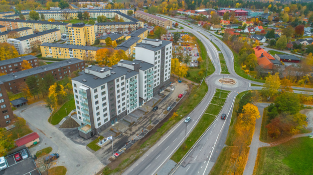 Aerial view of modern apartment buildings and a road roundabout surrounded by autumn trees in Sweden. Aerial view of modern apartment buildings and a road roundabout surrounded by autumn trees in Sweden.