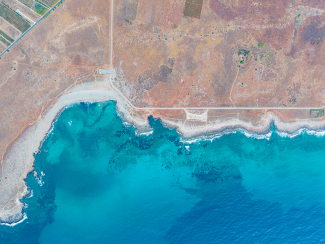 Aerial view of the turquoise Mediterranean Sea meeting the rugged coastline and arid landscape of Palermo Sicily Italy. Aerial view of the turquoise Mediterranean Sea meeting the rugged coastline and arid landscape of Palermo Sicily Italy.
