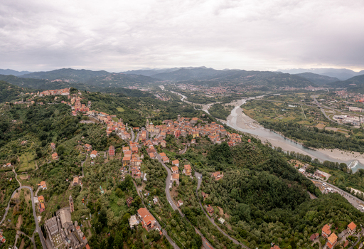 Aerial view of the historic village of Vezzano Ligure with terracotta rooftops surrounded by lush green hills and olive groves overlooking the Magra river valley in Vezzano Ligure Liguria Italy.