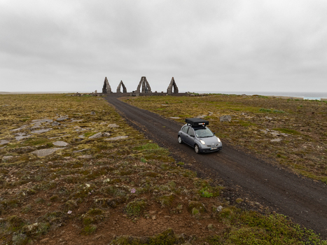 Aerial view of Arctic Henge with a car driving on a gravel road through the rugged landscape of Raufarhofn Nordurthing Iceland.