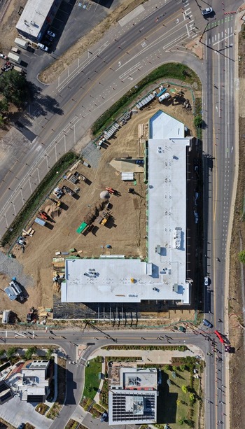 Aerial view of a construction site featuring a large building under development with heavy machinery and dirt ground in Boulder Colorado United States. Aerial view of a construction site featuring a large building under development with heavy machinery and dirt ground in Boulder Colorado United States.
