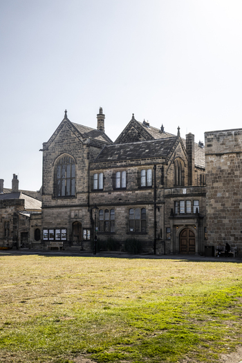 View of the historic stone architecture of Durham Castle with a grassy courtyard under a clear sky in Durham England United Kingdom. View of the historic stone architecture of Durham Castle with a grassy courtyard under a clear sky in Durham England United Kingdom.