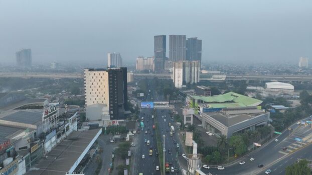 Bekasi Barat Indonesia 20 June 2026 Aerial view of the urban landscape featuring high rise buildings a busy highway with traffic and commercial structures under a hazy sky. Bekasi Barat Indonesia 20 June 2026 Aerial view of the urban landscape featuring high rise buildings a busy highway with traffic and commercial structures under a hazy sky.