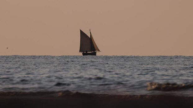 View of a sailboat on the calm sea at sunset France. View of a sailboat on the calm sea at sunset France.