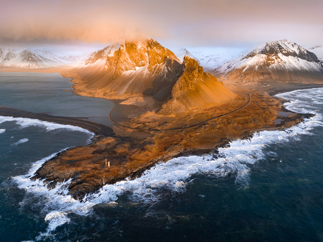 Aerial view of Hvalnes Lighthouse on a rocky promontory with the dramatic Vestrahorn mountain in the background under golden hour light in Sveitarfelagid Hornafjordur Iceland. Aerial view of Hvalnes Lighthouse on a rocky promontory with the dramatic Vestrahorn mountain in the background under golden hour light in Sveitarfelagid Hornafjordur Iceland.