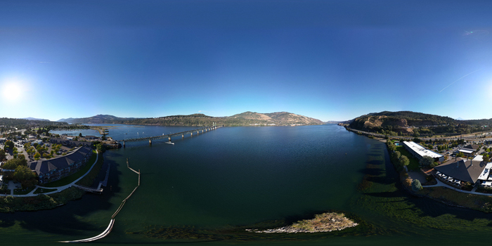 Aerial view of the Hood River bridge spanning the Columbia River with surrounding hills clear blue sky and waterfront buildings in Hood River County Oregon United States. Aerial view of the Hood River bridge spanning the Columbia River with surrounding hills clear blue sky and waterfront buildings in Hood River County Oregon United States.