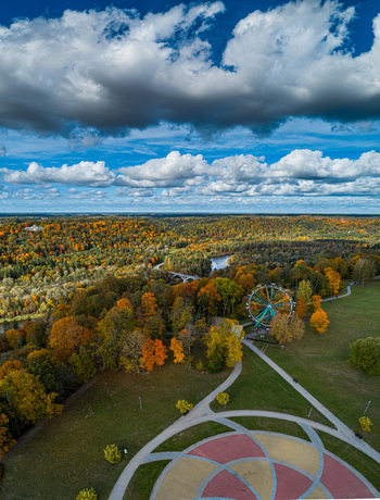 Aerial view of the ferris wheel in the park surrounded by vibrant autumn foliage and dense forests in Sigulda Sigulda Municipality Latvia. Aerial view of the ferris wheel in the park surrounded by vibrant autumn foliage and dense forests in Sigulda Sigulda Municipality Latvia.