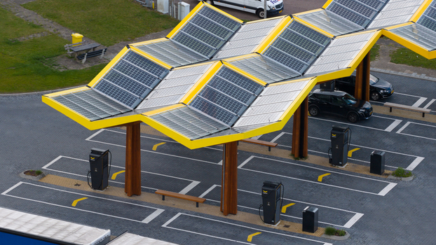 Oostzaan Netherlands 09 June 2026 Aerial view of the Fastned charging station featuring its iconic yellow solar panel canopy and electric vehicle charging infrastructure.