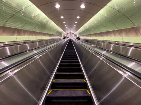 View of the long modern escalators at Grand Central Madison with a green arched ceiling and metallic finishes New York New York United States. View of the long modern escalators at Grand Central Madison with a green arched ceiling and metallic finishes New York New York United States.