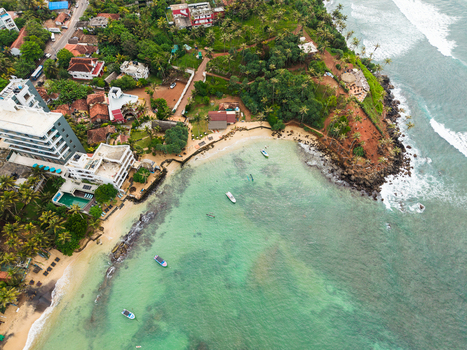 Aerial view of Coconut Tree Hill with turquoise ocean water small boats and lush tropical greenery in Mirissa Southern Province Sri Lanka. Aerial view of Coconut Tree Hill with turquoise ocean water small boats and lush tropical greenery in Mirissa Southern Province Sri Lanka.