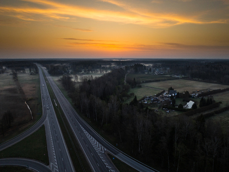 Aerial view of the highway intersection between the A5 and A8 roads surrounded by forests and fields during a golden sunrise in Olaine parish Olaine Municipality Latvia. Aerial view of the highway intersection between the A5 and A8 roads surrounded by forests and fields during a golden sunrise in Olaine parish Olaine Municipality Latvia.