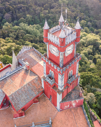 Aerial view of Pena Castle clock tower with forest in background view of the Romanticist castle on hilltop Sintra Lisbon Portugal.