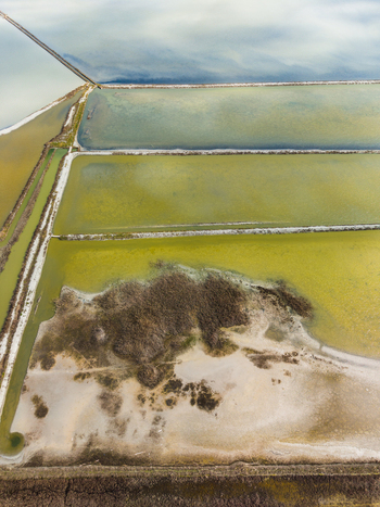 Aerial view of the colorful salt pans and evaporation ponds of Lake Atanasovsko with geometric dikes and coastal wetlands in Burgas Burgas Bulgaria. Aerial view of the colorful salt pans and evaporation ponds of Lake Atanasovsko with geometric dikes and coastal wetlands in Burgas Burgas Bulgaria.