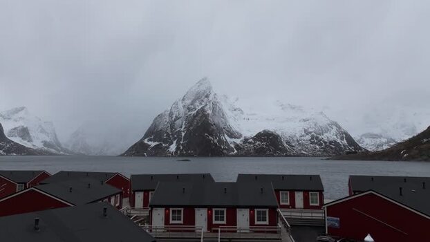 Aerial view of red cabins and mountains in Lofoten Norway.