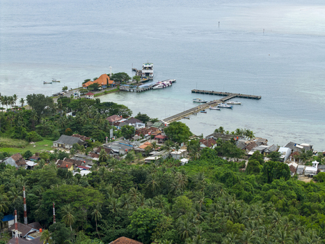 Aerial view of the Karimunjawa ferry harbour where boats rest in the calm turquoise waters against a backdrop of lush greenery Karimunjawa Jawa Tengah Indonesia. Aerial view of the Karimunjawa ferry harbour where boats rest in the calm turquoise waters against a backdrop of lush greenery Karimunjawa Jawa Tengah Indonesia.
