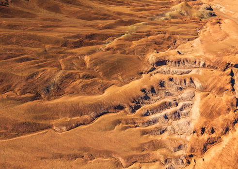Aerial view of the arid rugged landscape of the Atacama Desert with deep ravines and textured rock formations in San Pedro de Atacama Antofagasta Chile. Aerial view of the arid rugged landscape of the Atacama Desert with deep ravines and textured rock formations in San Pedro de Atacama Antofagasta Chile.
