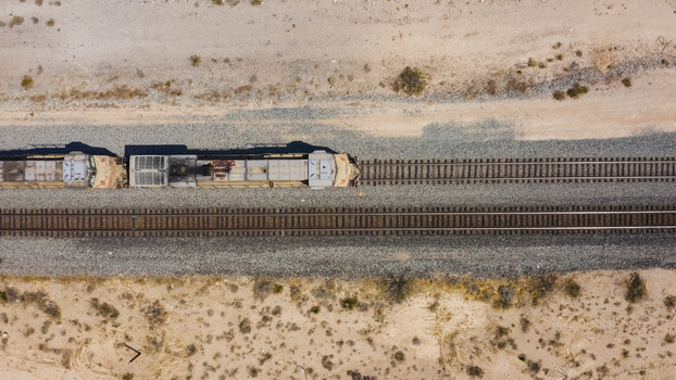 Aerial view of a freight train traveling along tracks through an arid desert landscape in the United States.