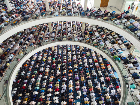 Dhaka Bangladesh 19 June 2026 Aerial view of a large congregation of people praying inside a mosque with rows of worshippers kneeling on the floor in a spacious hall.