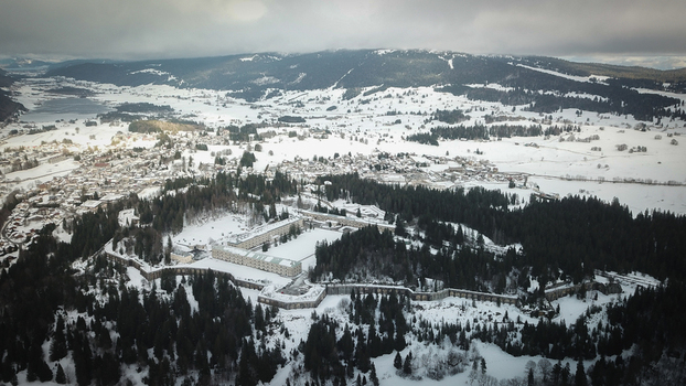 Aerial view of Le Fort des Rousses surrounded by snow covered pine forests and the winter landscape of the village Les Rousses Bourgogne Franche Comte France.