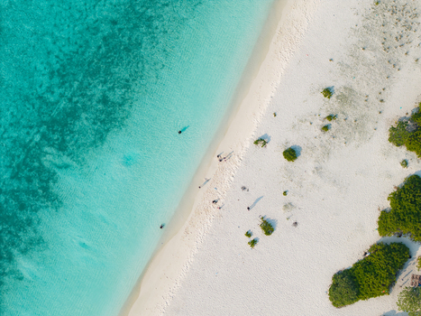 Aerial view of turquoise waters meet the pristine white sands of the beach a serene contrast captured from above Dhidhdhoo Thiladhunmathi Atoll Maldives.