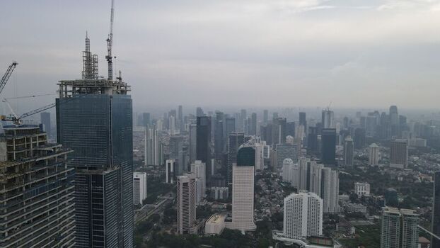 Kecamatan Menteng Indonesia 03 December 2021 Aerial view of the Jakarta Pusat skyline featuring modern skyscrapers and construction cranes under an overcast sky. Kecamatan Menteng Indonesia 03 December 2021 Aerial view of the Jakarta Pusat skyline featuring modern skyscrapers and construction cranes under an overcast sky.