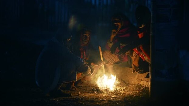 View of people sitting around a small fire at night Bangladesh. View of people sitting around a small fire at night Bangladesh.