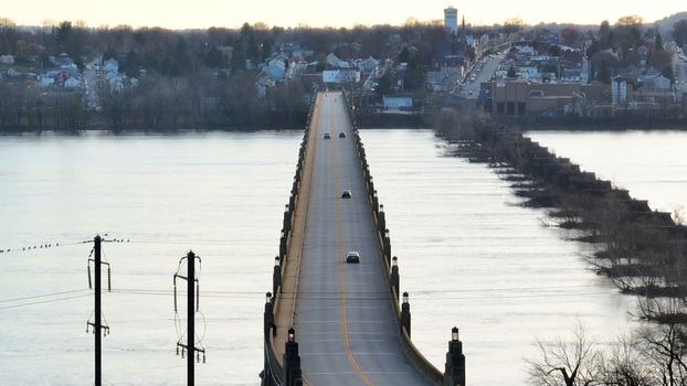 Aerial view of the Veterans Memorial Bridge spanning the Susquehanna River with cars driving across and the town of Columbia in the background at sunset in Columbia Pennsylvania United States. Aerial view of the Veterans Memorial Bridge spanning the Susquehanna River with cars driving across and the town of Columbia in the background at sunset in Columbia Pennsylvania United States.
