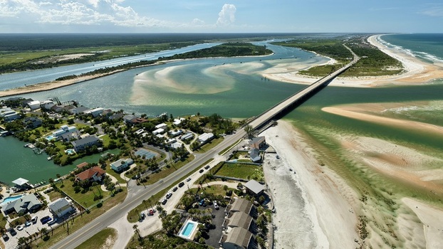 Aerial view of Matanzas Inlet with its turquoise waters sandbars and the bridge connecting the coastal landscape in St. Johns County Florida United States. Aerial view of Matanzas Inlet with its turquoise waters sandbars and the bridge connecting the coastal landscape in St. Johns County Florida United States.