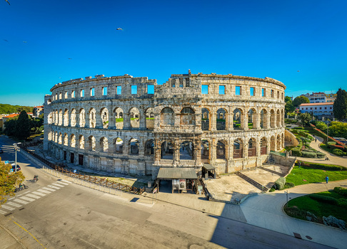 Aerial view of the ancient Roman amphitheater its weathered stones standing against the clear blue sky a testament to history Pula Istria County Croatia.