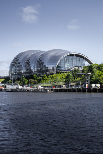 View of The Sage Gateshead a modern glass and steel building with a distinctive curved roof situated on the banks of the River Tyne in Newcastle upon Tyne England United Kingdom. View of The Sage Gateshead a modern glass and steel building with a distinctive curved roof situated on the banks of the River Tyne in Newcastle upon Tyne England United Kingdom.